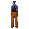Back view of the Rossignol Outerlimits Insulated Bib in DEEP CARAMEL colourway, women model