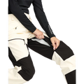 Image of the The Volcom Stone Mica 20K Snowboard Pants – Womens in Bone colourway. Features contrast black knee, inner cuff and upper backside patches; zip and button fastening, belt loops, hip and thigh zip pockets, and inner thigh vents with zip closure.