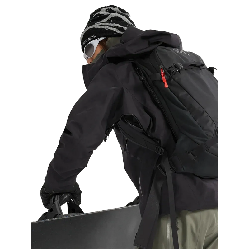 Detail view of a woman wearing the Sentinel Ski Jacket in Black featuring a zipepred pit vent. 