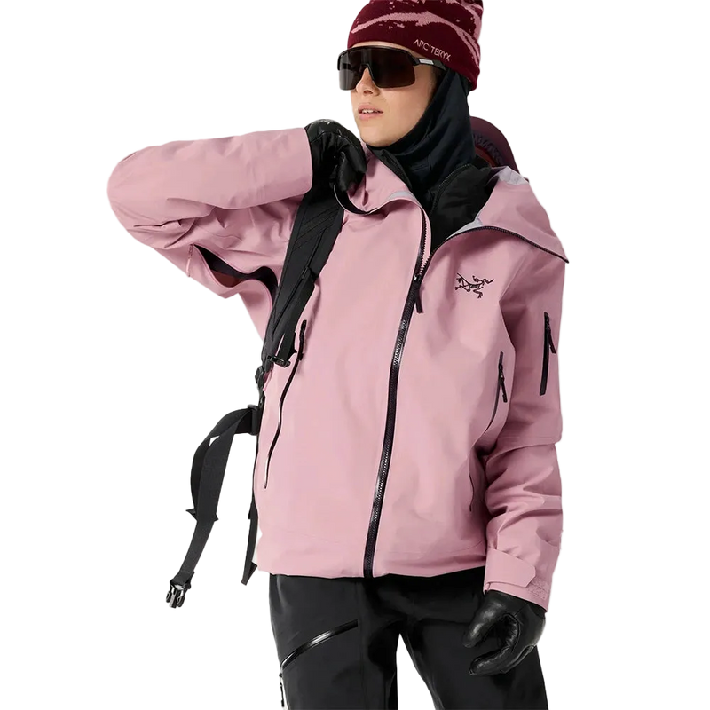 Front view of a woman wearing the Sentinel Ski Jacket in Bliss Black featuring  a full zip front, underarm zip vent, zip pockets at the sides and sleeve, and adjustable cuffs. 