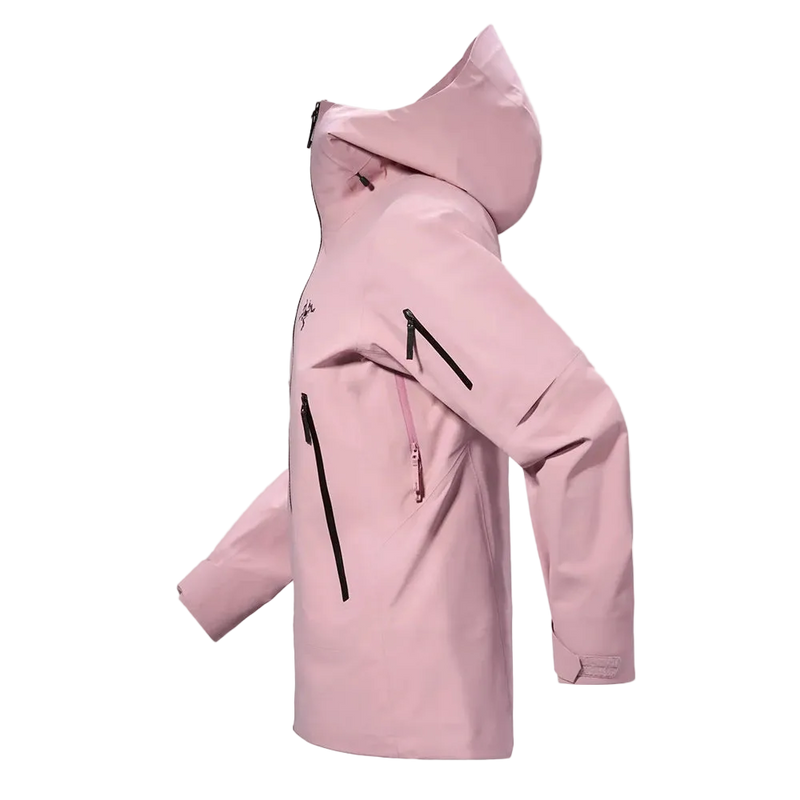 Side view of the Sentinel Ski Jacket in Bliss Black, featuring a storm hood with toggle adjustment, underarm zip vents, zip pockets at the sides and on the sleeve, adjustable cuffs, and a blush pink tone with contrast black hardware and logo on the chest.