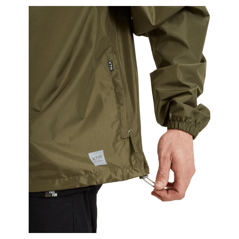 Pocket view of the XTM Stash 2L Rain Jacket in Kalamata colourway, unisex's model