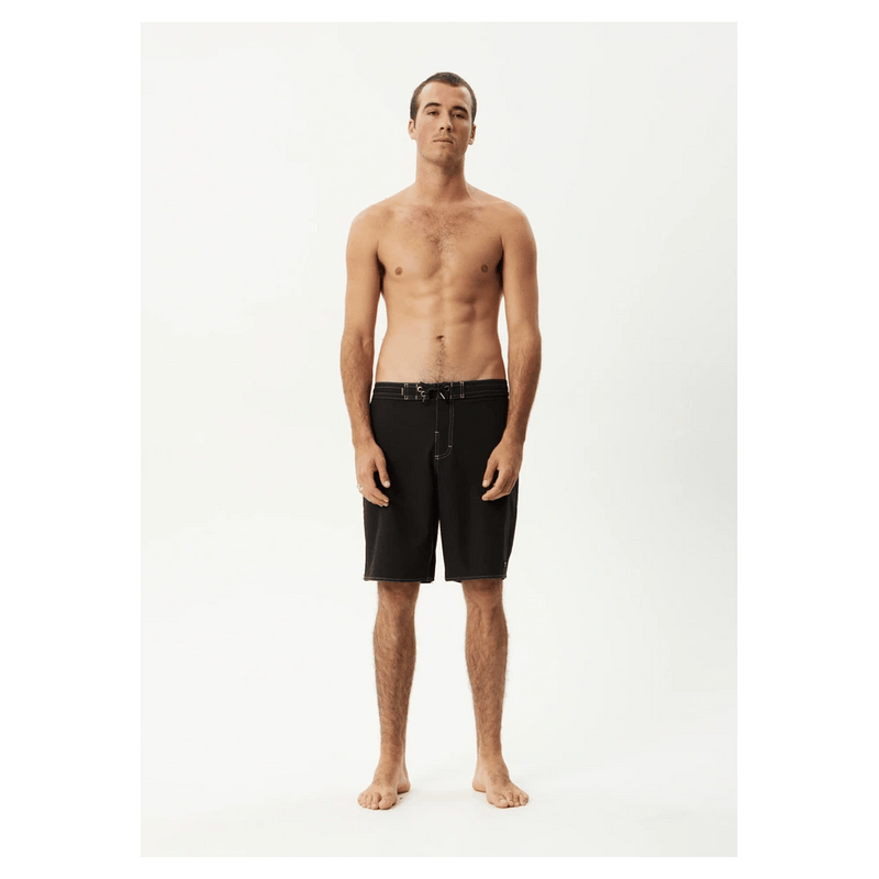 Afends Surf Related V2 black fixed waist boardshorts with drawstring worn by a man on a white background.