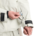 Hand pulling a lift pass from the zippered sleeve pocket of a white Analog Hardpack 3L GORE-TEX Snowboard Jacket.