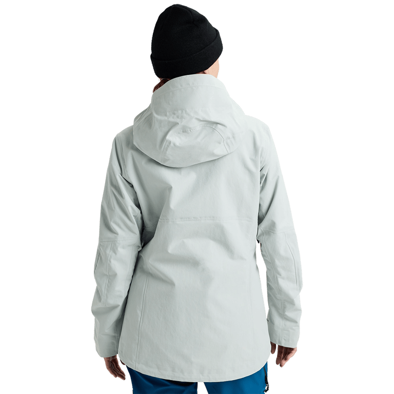Rear view of a light grey Burton AK Upshift Gore-Tex 2L women's snowboard jacket with a hood and black beanie.