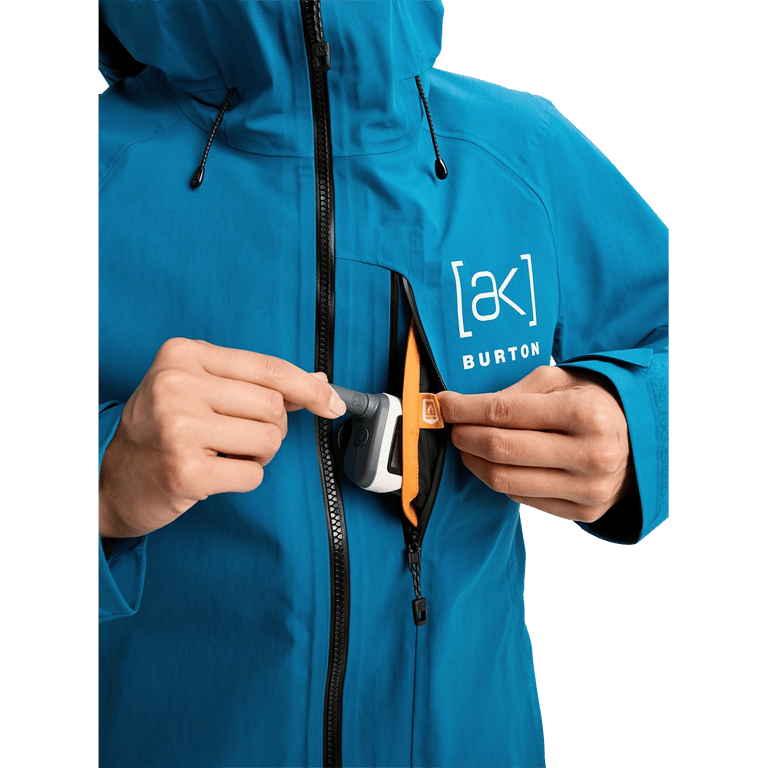 Blue Burton AK Upshift jacket with a zippered chest pocket, orange lining, and white logo.