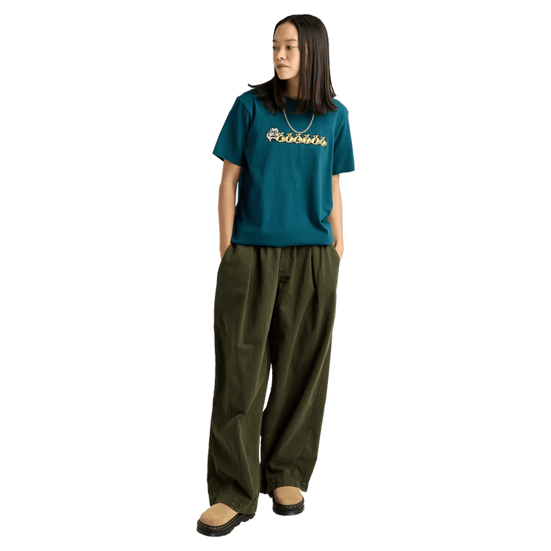 Teal Burton Ransacked short-sleeve t-shirt with chest graphic, worn with olive green wide-leg pants.