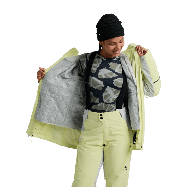 Woman wearing a pale yellow Burton Reserve 3-In-1 Snowboard Jacket showing the grey quilted inner liner.