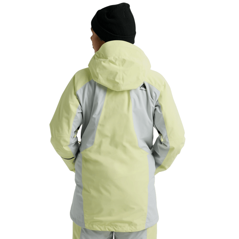 Back view of a light yellow and grey color-blocked women's hooded snowboard jacket with a small logo on the shoulder.