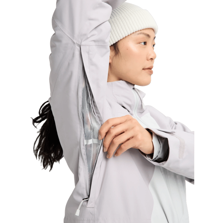 Woman opening the mesh-lined underarm vent on a light grey Burton Reserve Insulated Snowboard Jacket.