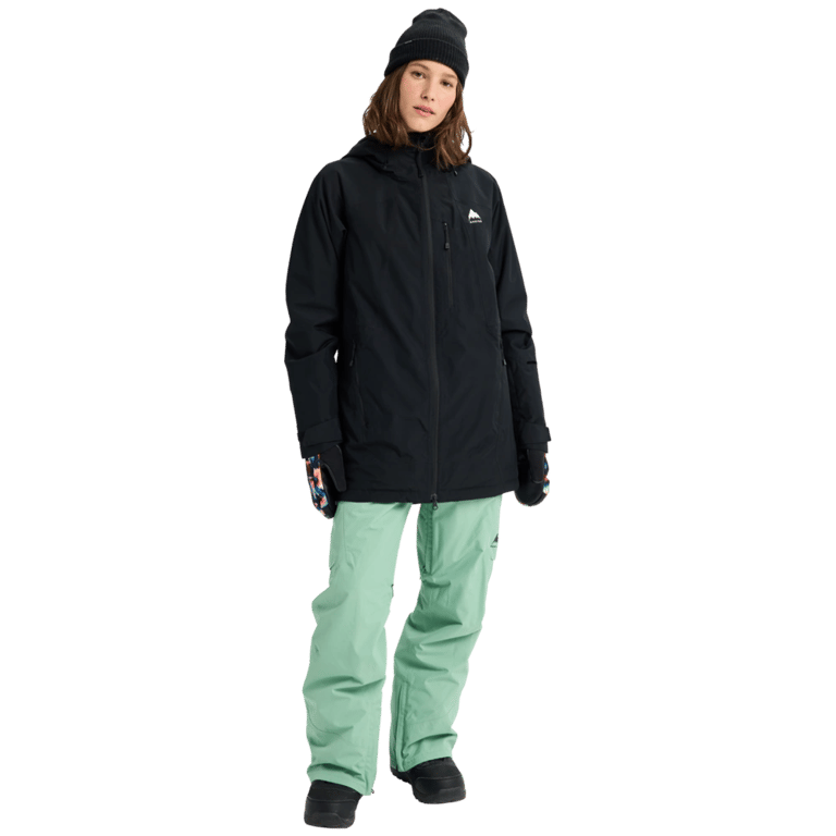 Woman wearing a black Burton Reserve Insulated Snowboard Jacket with a hood and mint green pants.