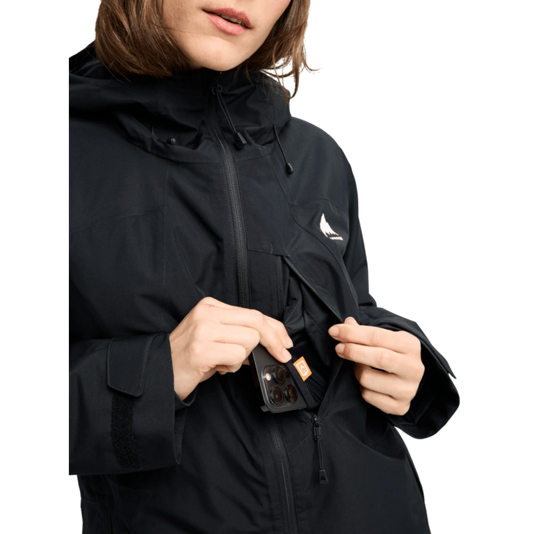 Black Burton Reserve Insulated Snowboard Jacket for women with a phone being placed in a zippered chest pocket.