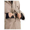 Tan Burton Reserve women's snowboard jacket showing a zippered chest pocket with a phone and black wrist gaiters.