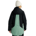 Back view of a black and sage green Burton Reserve Insulated Snowboard Jacket with a hood and white beanie.