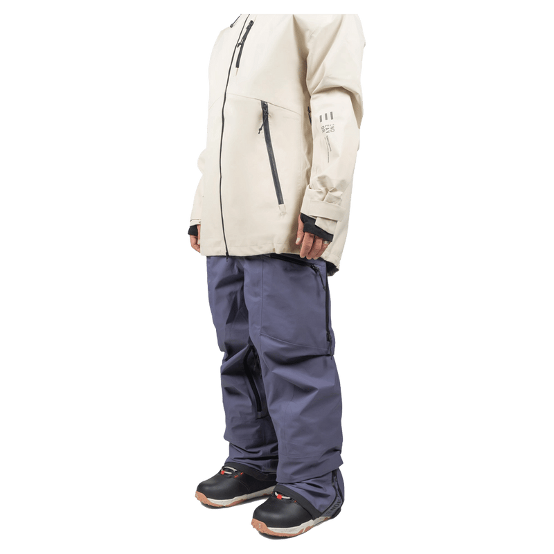 Endeavor 3L Shelter Bib Snowboard Pants in slate blue, side view showing baggy fit, worn with a cream jacket.
