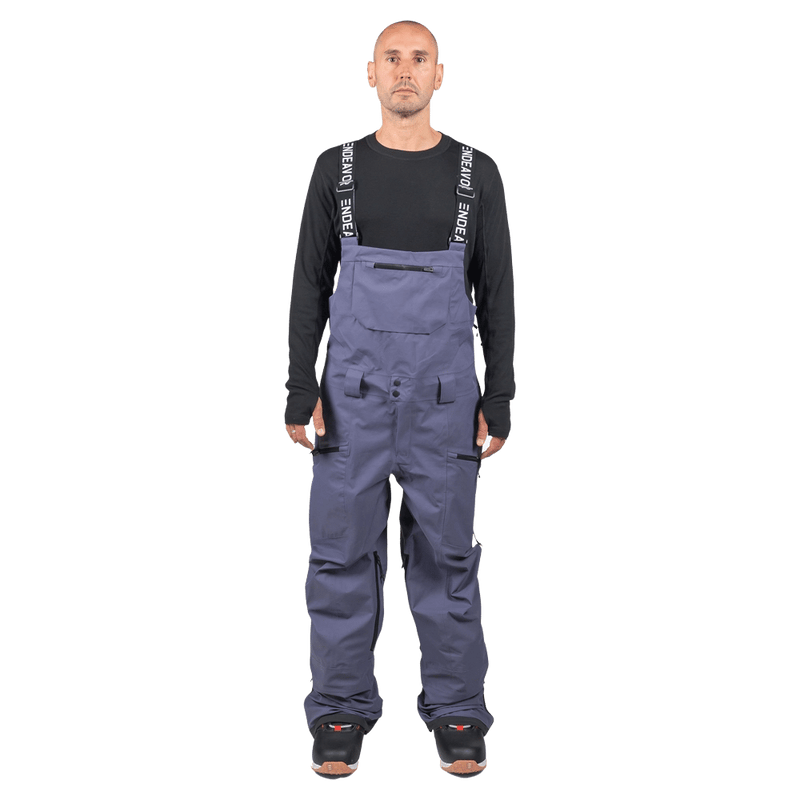 Endeavor 3L Shelter Bib Snowboard Pants in slate blue with branded suspenders and zippered pockets on a model.