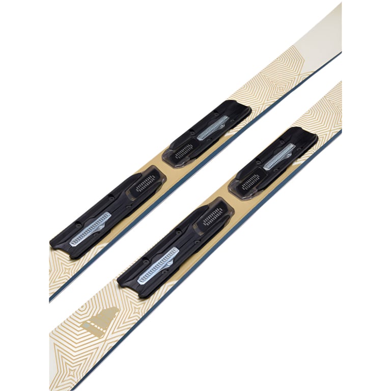 Close-up of cream and gold K2 Blur 76 women's skis with black binding plates and geometric line patterns.