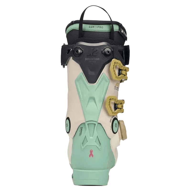 Rear view of cream and mint green K2 Anthem 95 ski boot with gold buckles and a pink ribbon logo on the heel.