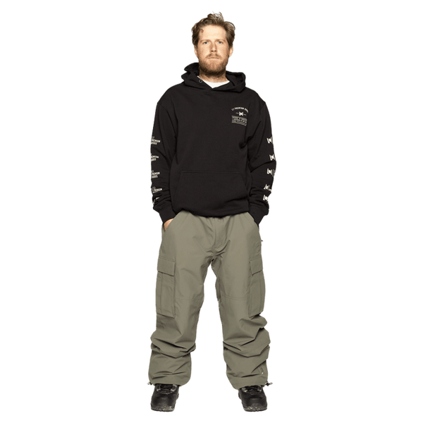 Olive green L1 Dixon Cargo Snowboard Pants with large side pockets and a baggy fit on a model.