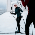Woman cross-country skiing in blue and black Madshus Pulse Boa Skate Boots on a groomed snow trail.