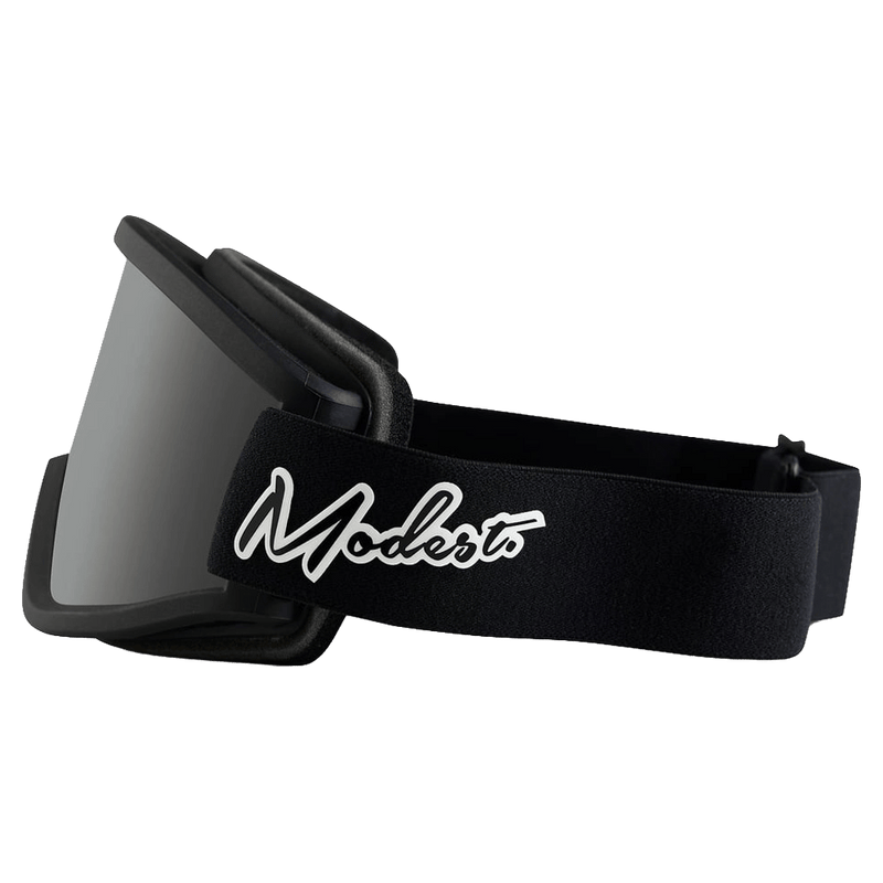 Side profile of black Modest Team XL Goggles with a grey lens and white script logo on the black strap.