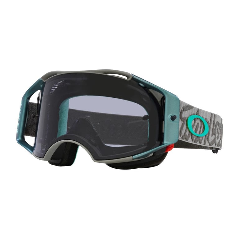 Oakley Airbrake MTB goggles with a teal frame, dark tinted lens, and grey patterned strap with a teal logo.