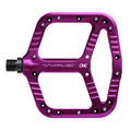 Top view of a purple One Up Components Wave flat mountain bike pedal with metal grip pins and wide platform.