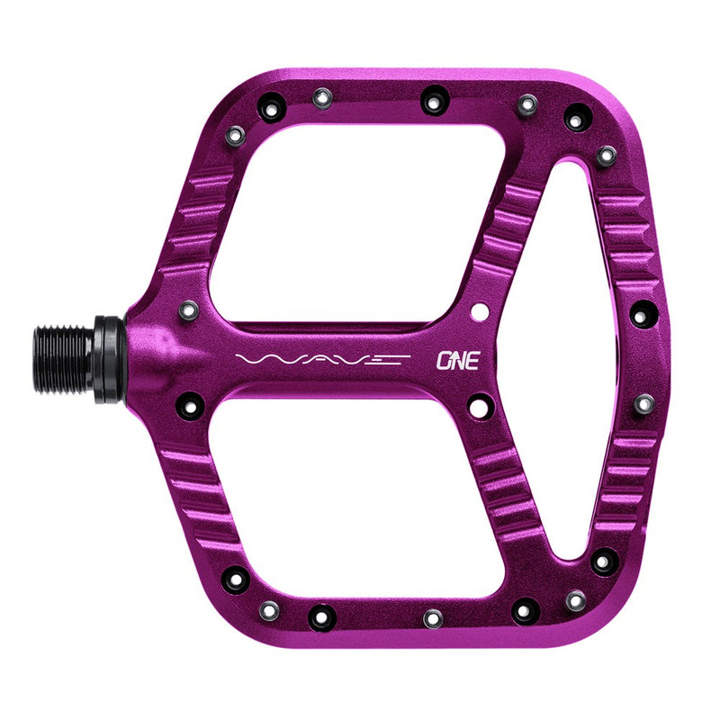 Top view of a purple One Up Components Wave flat mountain bike pedal with metal grip pins and wide platform.