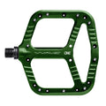 Green One Up Components Wave flat mountain bike pedal with a wavy platform design and silver traction pins.
