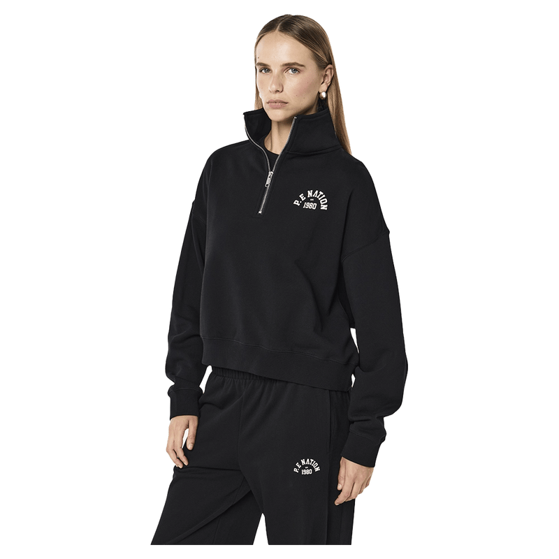 Side view of the PE NATION Established Oversized Quarter Zip Black Sweater,  26/27 Womens's model