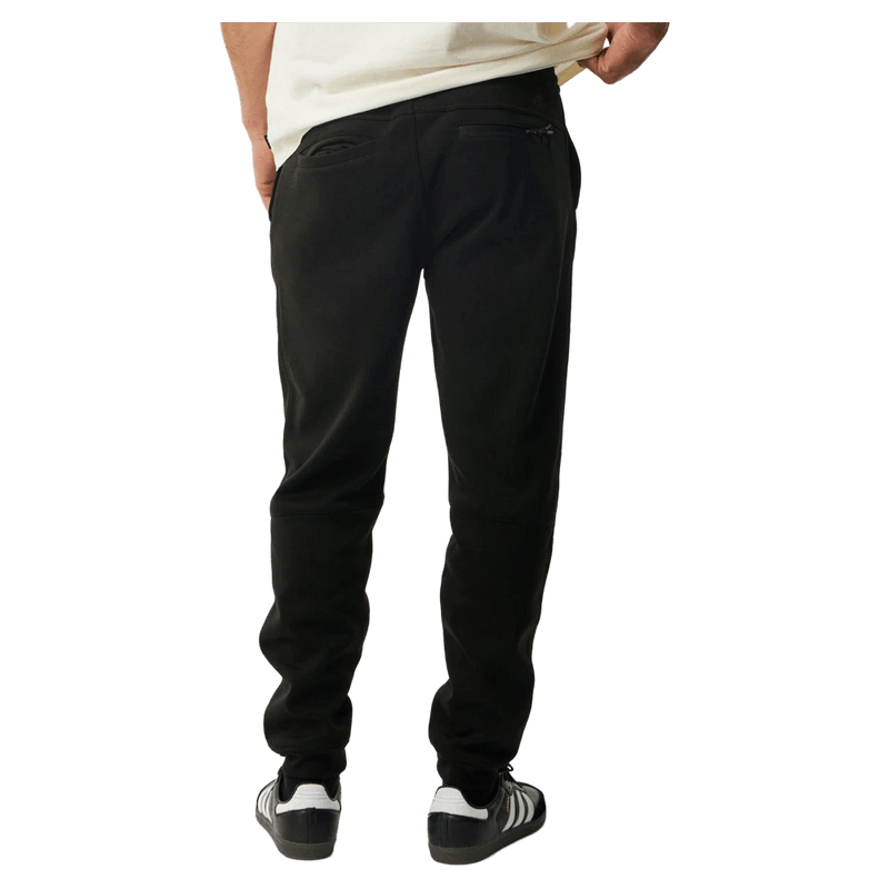 Rear view of black Rip Curl Anti Series Departed Trackpants with a tapered fit, cuffed ankles, and zip back pocket.