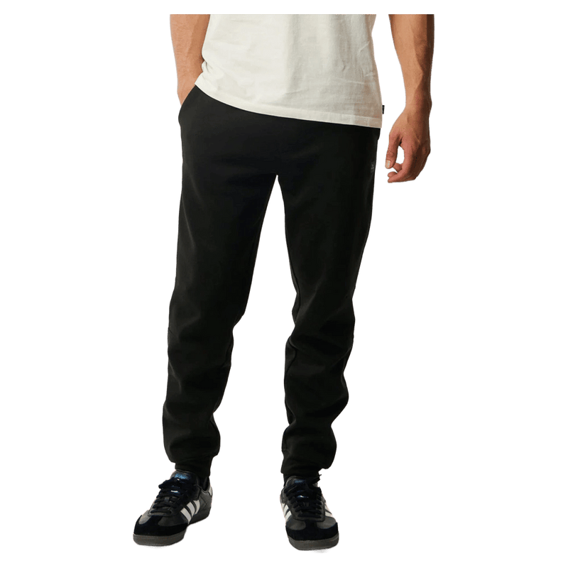 Black Rip Curl Anti Series Departed Trackpant with a tapered fit, cuffed ankles, and side pockets on a model.
