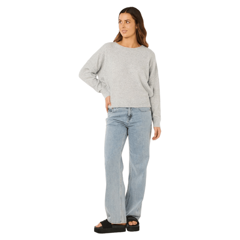Rip Curl Emily light grey knit sweater for women, featuring a crew neck and long sleeves, worn with light blue jeans.