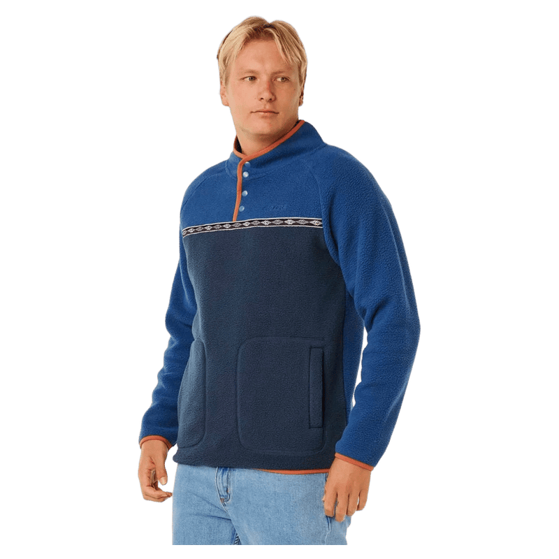 Two-tone blue Rip Curl Heritage Polar Fleece with snap-button collar, patterned chest trim, and orange accents.