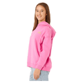 Side profile of a girl wearing a bright pink Rip Curl Surf Puff Heritage hoodie with a small yellow chest logo.