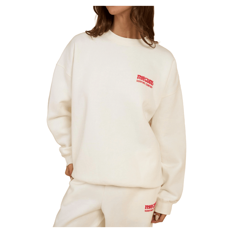 Rip Curl Surf Puff Inspired Crew in cream with a small red chest logo, worn by a woman.