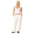 Woman wearing off-white Rip Curl Surf Puff wide leg trackpants with a drawstring waist and red logo on the hip.