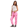 Bright pink Rip Curl trackpants with elastic cuffs and logo, worn with a white tank top and black high-top sneakers.