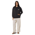 Woman wearing a charcoal Rip Curl Surf Revival Heritage Hoodie with a chest logo and cream wide-leg pants.