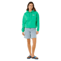 Woman wearing a bright green Rip Curl Surf Revival Heritage Hoodie with a front pocket and light blue denim shorts.