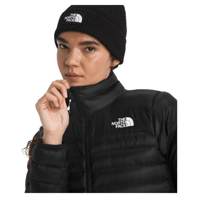 View of a woman wearing The North Face Terra Peak Jacket for Women in Black featuring a full front two-way zip with internal draft flap, a short stand collar and a heat transfer white logo on the left chest