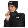 View of a woman wearing The North Face Terra Peak Jacket for Women in Black featuring a full front two-way zip with internal draft flap, a short stand collar and a heat transfer white logo on the left chest