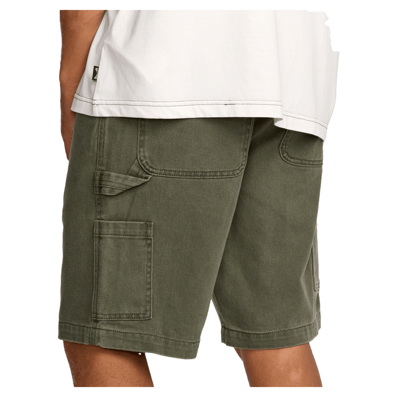 Side cropped view of a man wearing the Bad Dog Workwear Shorts from Billabong in Dark Military. Featuring a utility loop and tool pocket to the side.