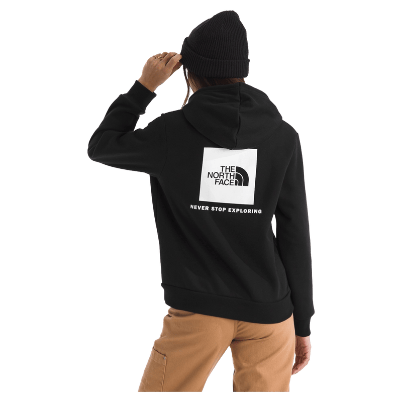 Rear view of a woman wearing The North Face Evolution Box NSE Hoodie for Women in Black featuring a box logo graphic in white and black.