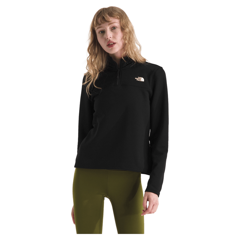 View of a woman wearing The North Face Cedar Trail Grid Fleece ¼ Zip Jacket for Women in Black featuring a quarter zip and embroidered white logo on the left chest