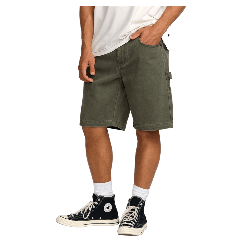 Side cropped view of a man wearing the Bad Dog Workwear Shorts from Billabong in Dark Military.