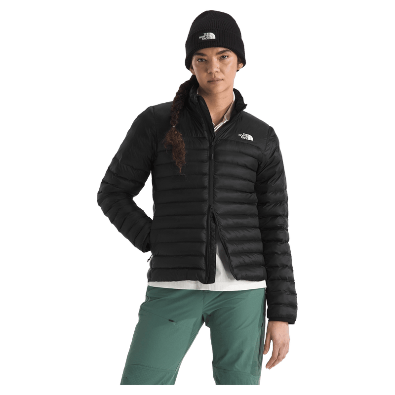 View of a woman wearing The North Face Terra Peak Jacket for Women in Black featuring a full front two-way zip with internal draft flap, zip side pockets, and a heat transfer white logo on the left chest