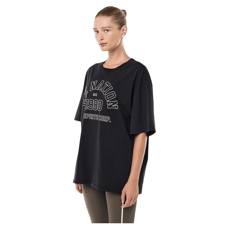 Side view of the PE NATION Altitude Tee Washed Black Tee,  26/27 Womens's model