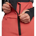 Close-up of coral Rojo Softshell High Rise Ski Pants showing the front zipper and high-waisted softshell fabric.