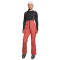 Women's Rojo high-rise softshell ski pants in coral red with black suspenders and front zipper.